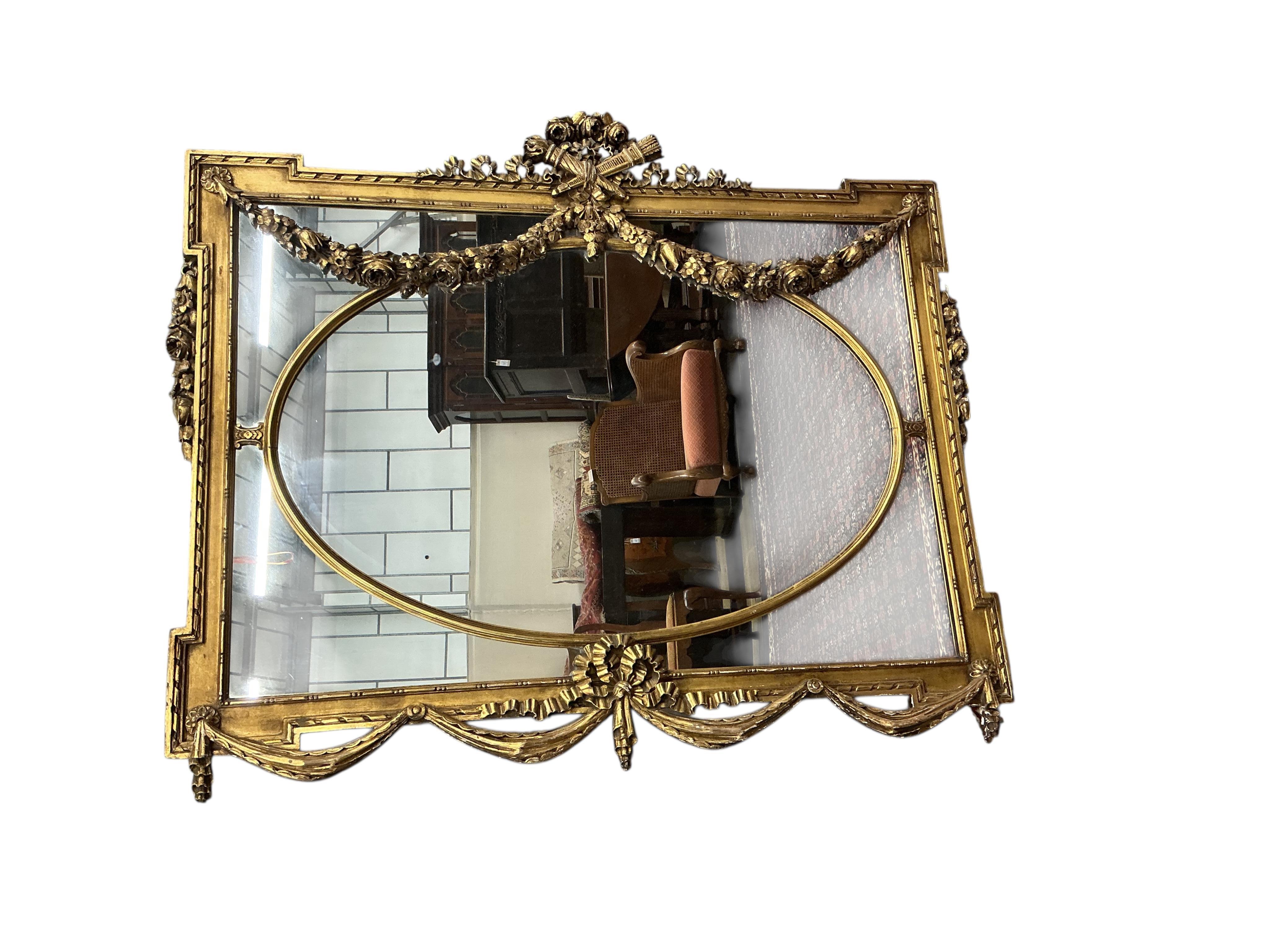 A Victorian style giltwood and composition overmantel mirror with cross torch and quiver crest, width 136cm, height 110cm
